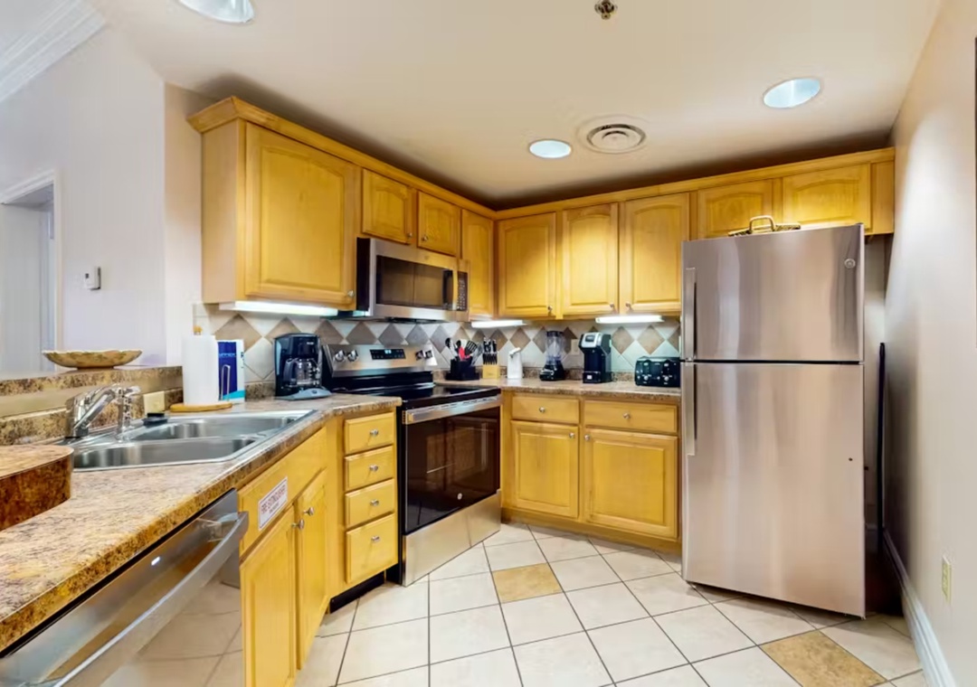 Your fully equipped kitchen features granite countertops, stainless steel appliances, and warm wood cabinets—perfect for preparing memorable meals during your stay.