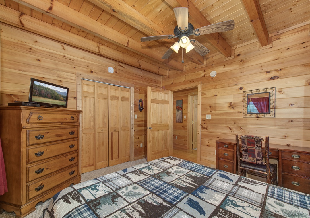 Cozy log cabin bedroom with rustic charm surrounds you in warm wood and mountain comfort.