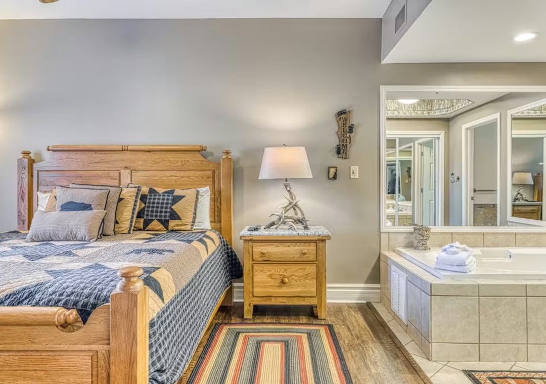 Unwind in your cozy bedroom featuring rustic wood furnishing and a luxurious spa-style tub for ultimate relaxation after your adventures.