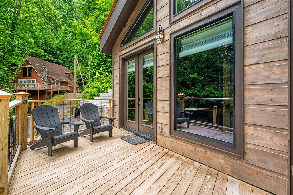 Step outside to your private deck surrounded by towering trees, where Adirondack chairs invite you to sip morning coffee or unwind as sunlight filters through the forest canopy.