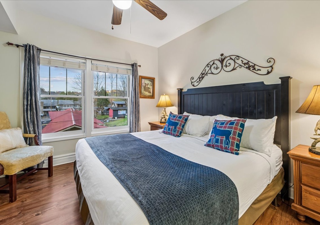 Your peaceful retreat awaits with rustic wood beams overhead and crisp linens on your comfortable bed, perfectly positioned to enjoy views of the charming neighborhood below.