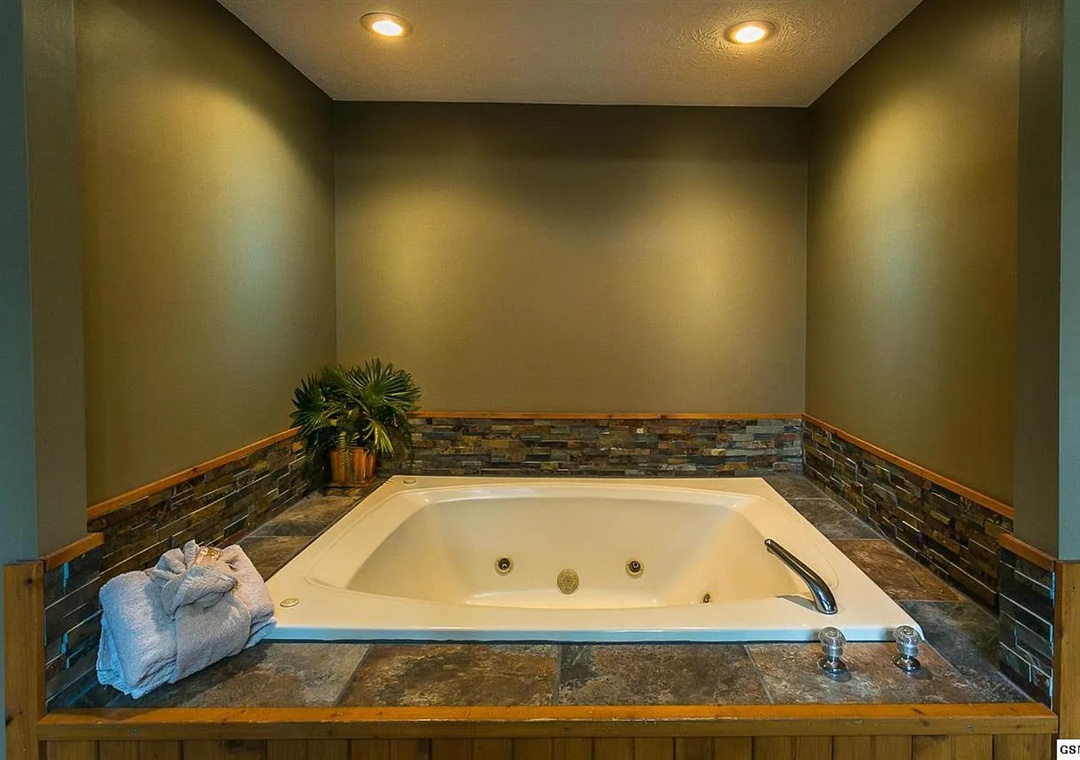 Step into your private spa retreat. Sink into this spacious jetted tub with stone tile surround, ambient lighting, and plush towels awaiting your arrival.