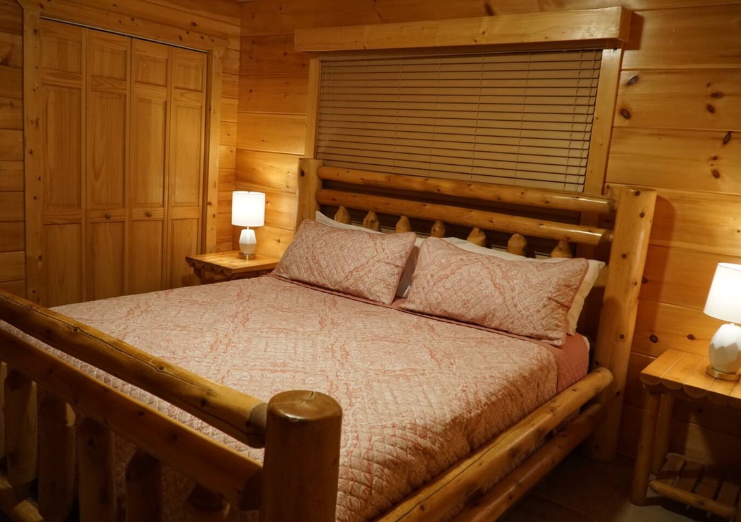 Sink into this cozy log cabin bedroom where rustic wood surrounds you with warmth and comfort for peaceful mountain nights.