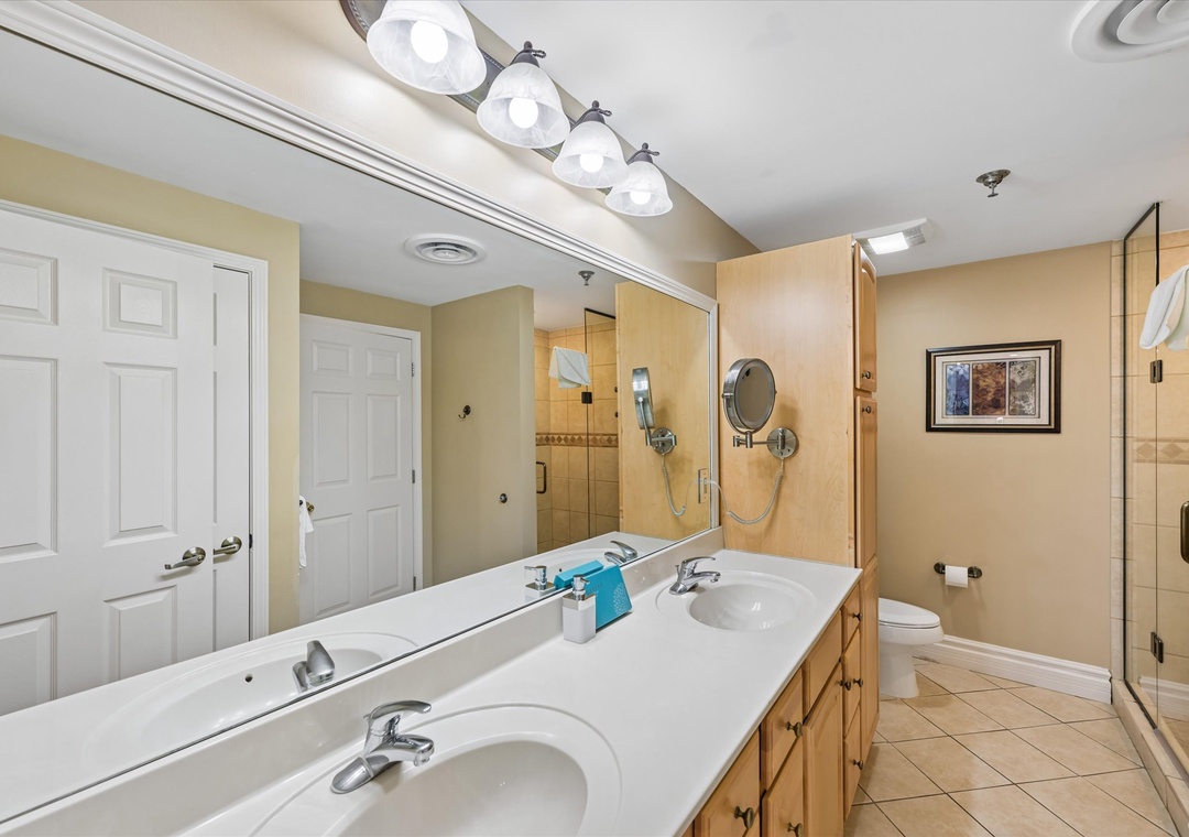 Spacious master bathroom with dual vanities, elegant lighting, and separate shower - your perfect retreat after busy vacation days.