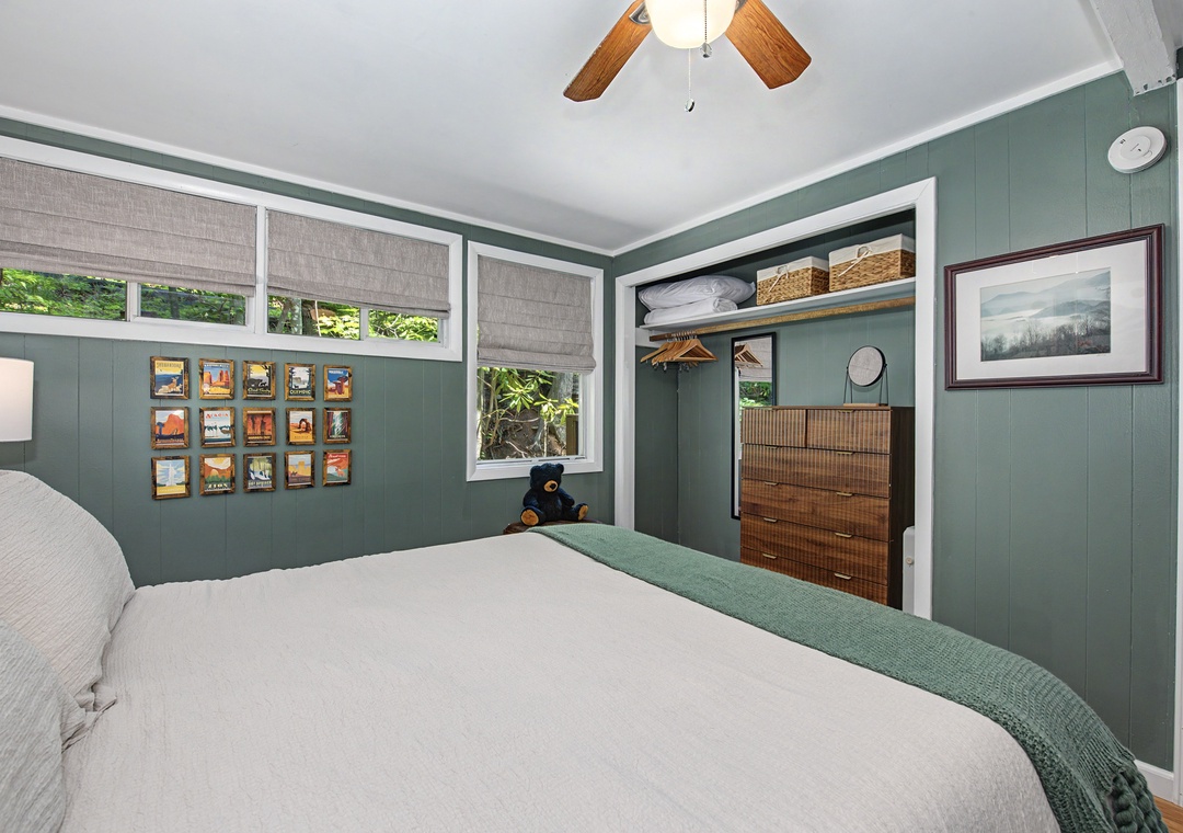Your cozy bedroom features soft linens, calming sage-green walls, and a ceiling fan for comfort. Natural light, warm wood accents, and smart closet storage create a peaceful retreat for restful nights.