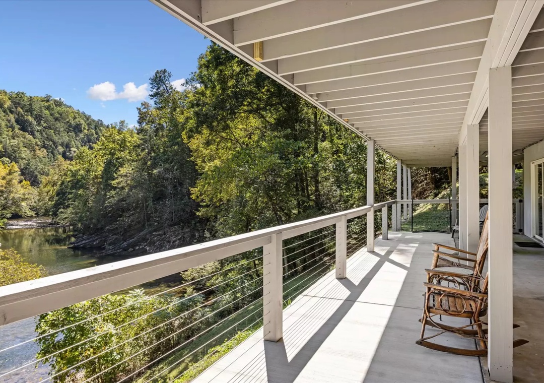 Unwind on your private riverside balcony where gentle rocking chair moments meet stunning water views through sleek modern railings.