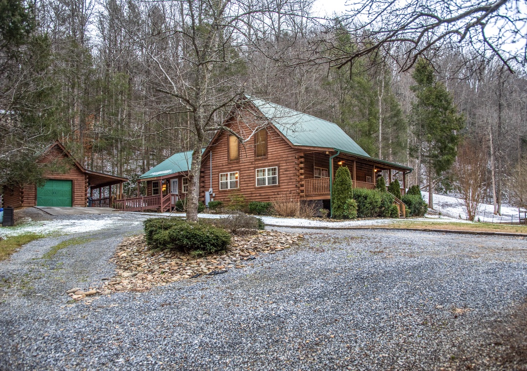 This charming log cabin retreat sits nestled among winter trees, offering rustic comfort with modern conveniences and ample parking for your mountain getaway.