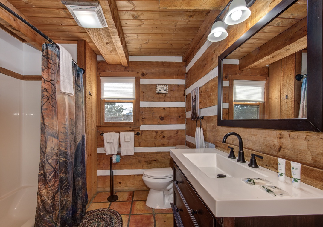 Step into your rustic bathroom with exposed wooden beams, modern fixtures, and charming cabin-style details that blend comfort with wilderness charm.