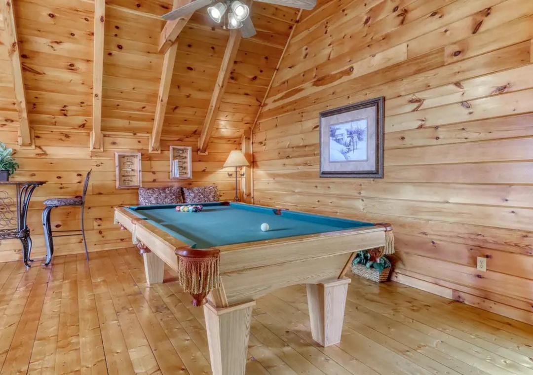 Challenge your travel companions to a game of pool in this inviting cabin game room, where warm knotty pine walls and soaring vaulted ceilings create the perfect retreat for friendly competition.