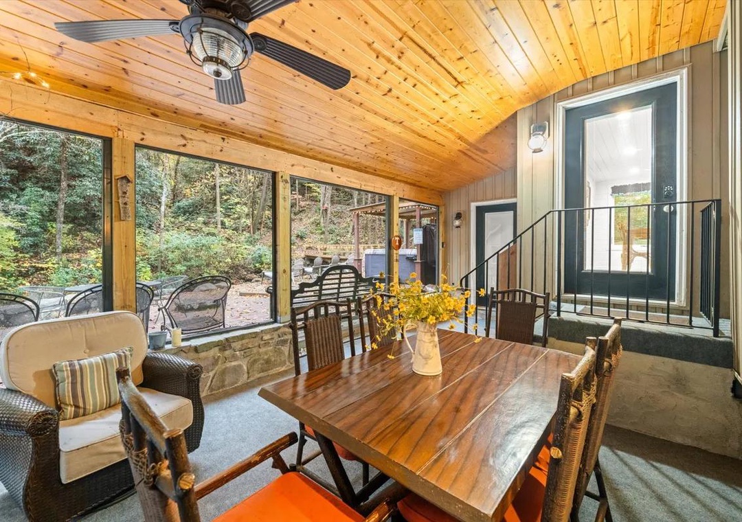 Gather around the warm wood dining table with forest views framing every meal. Your screened porch keeps you close to nature while the ceiling fan keeps you comfortable—perfect for morning coffee or evening conversation.