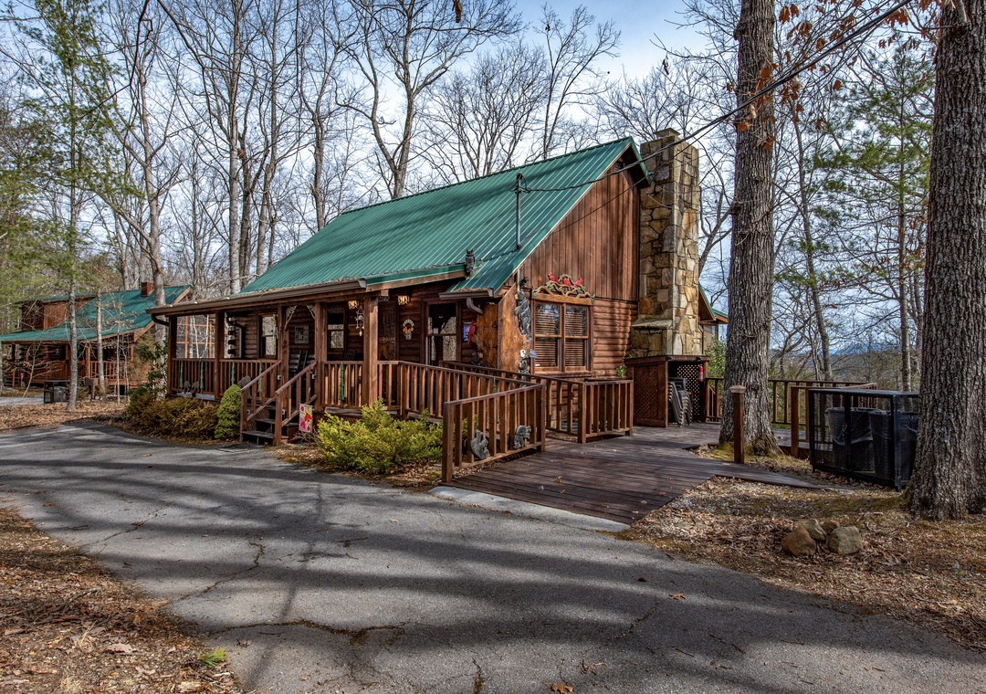 A charming log cabin nestled among towering trees with a welcoming covered porch and stone chimney.