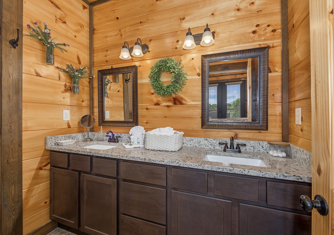 Freshen up in your warm, rustic bathroom with dual vanities, granite counters, and natural wood accents—a peaceful space designed for comfort and ease.