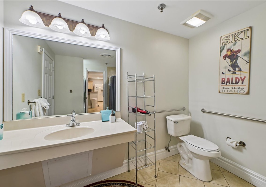 Your spacious bathroom features warm lighting, grab bars for safety, and ski-themed artwork for mountain charm.