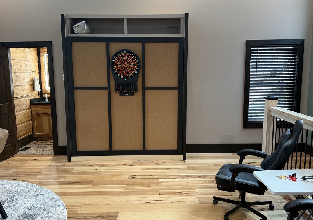 Challenge friends to darts in your private game room, complete with protective backdrop and comfortable seating for spectators.