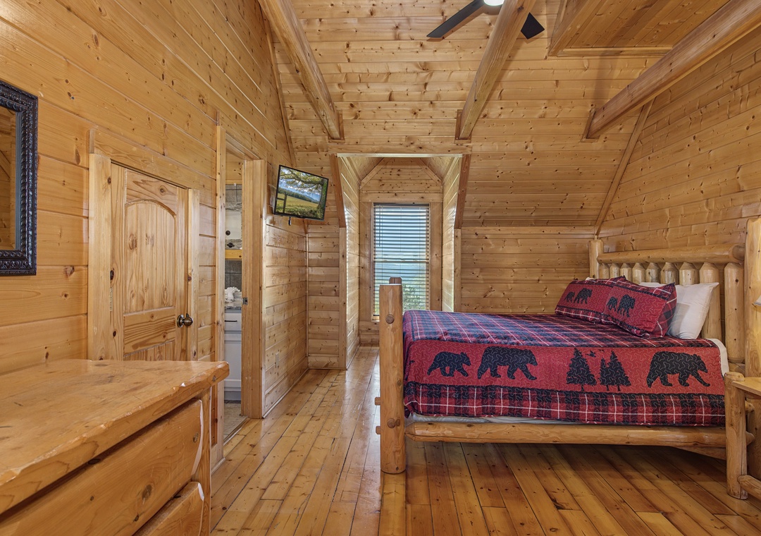 Drift off in your rustic log bedroom, where handcrafted wooden beams and cozy bear-themed bedding create the perfect mountain retreat atmosphere.