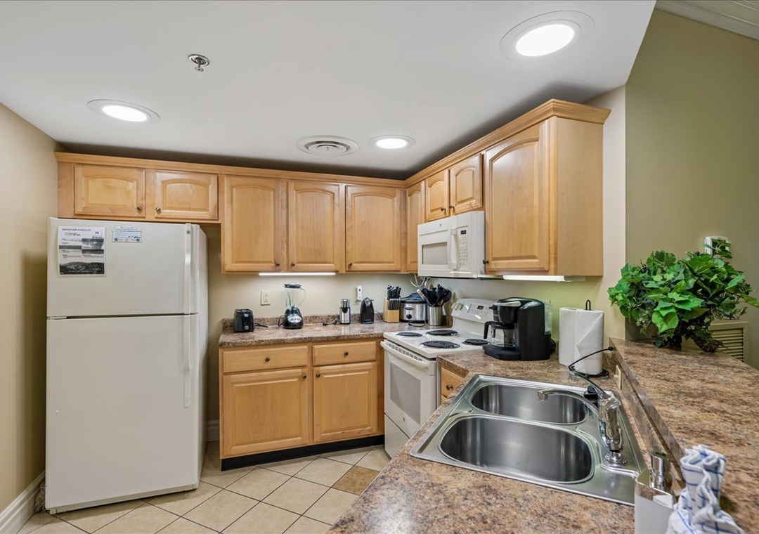 Your fully-equipped kitchen awaits with granite countertops, warm wood cabinets, and everything you need to create memorable meals during your stay.