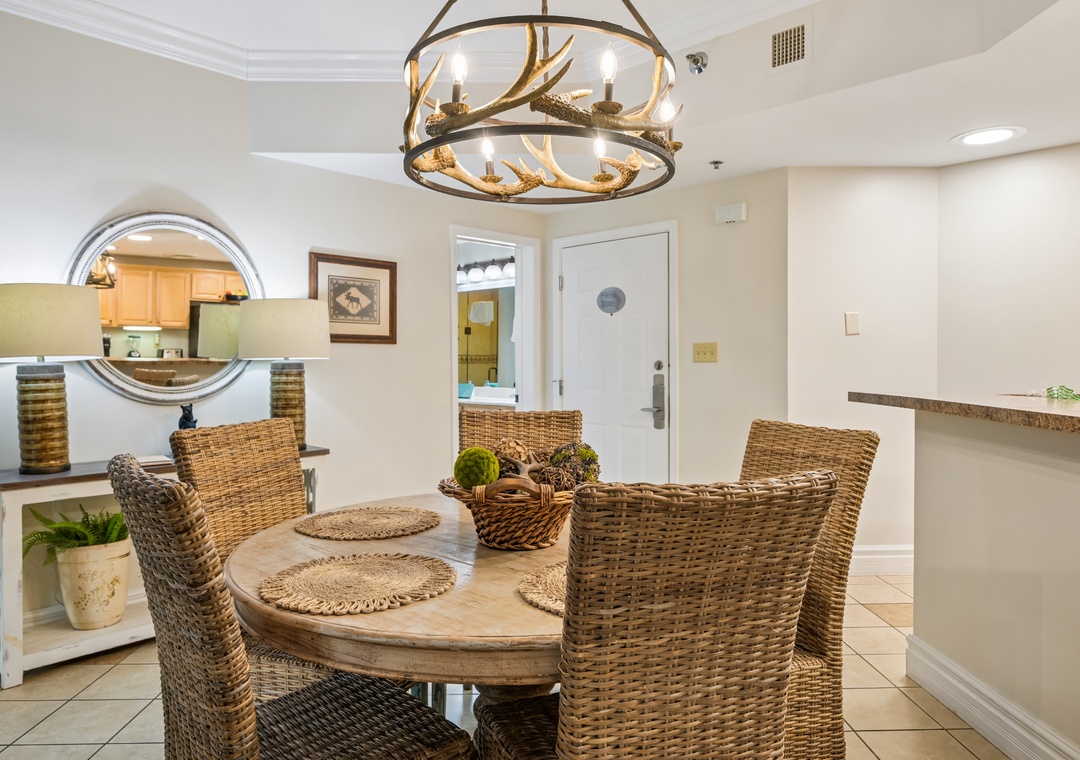Gather around this charming wicker dining set where memorable meals await under rustic antler lighting in your welcoming coastal retreat.