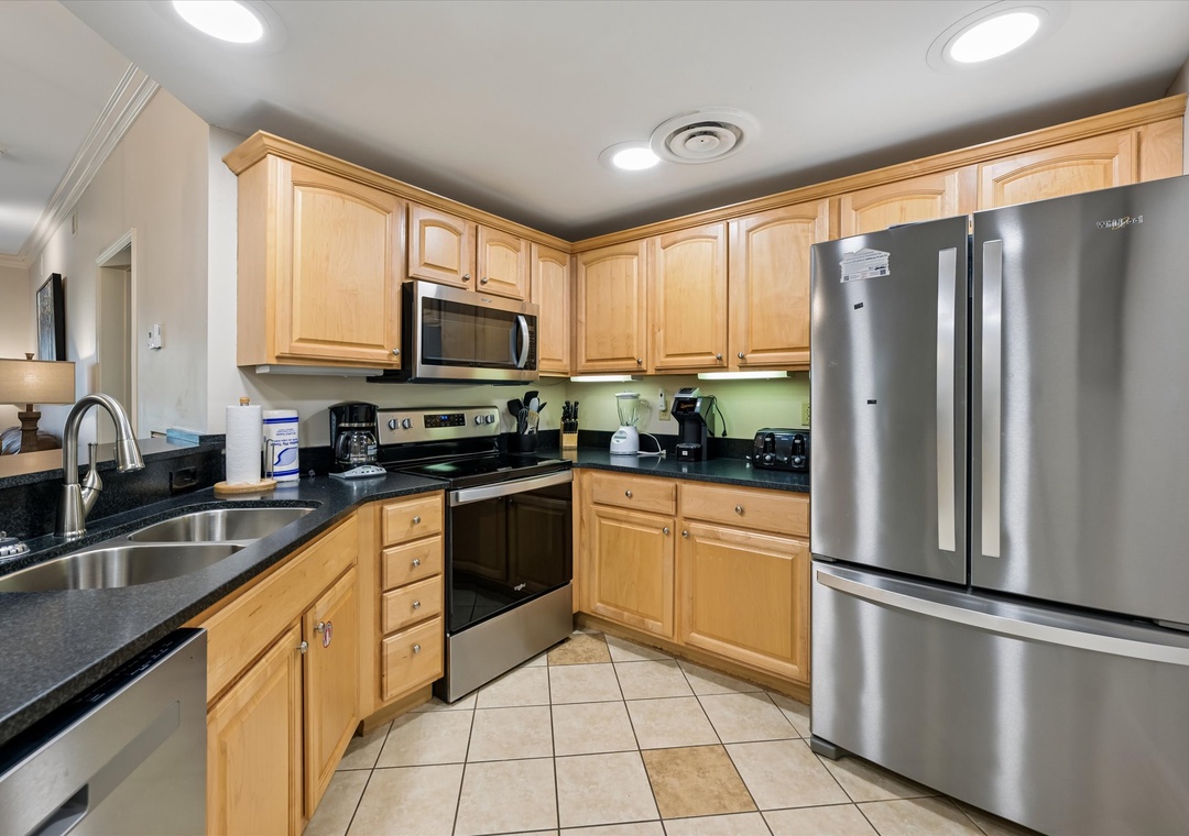 Your fully equipped kitchen features warm wood cabinets, granite counters, and stainless appliances - perfect for preparing delicious meals together.