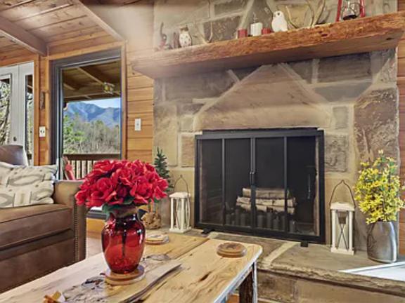 Curl up beside the stone fireplace in this inviting living room where wood beams and mountain views create a perfect retreat after a day of exploring.