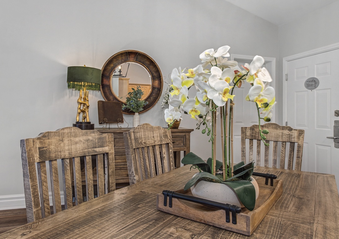 Gather around this rustic dining table with elegant orchid centerpiece, where memorable meals await in your beautifully appointed space.