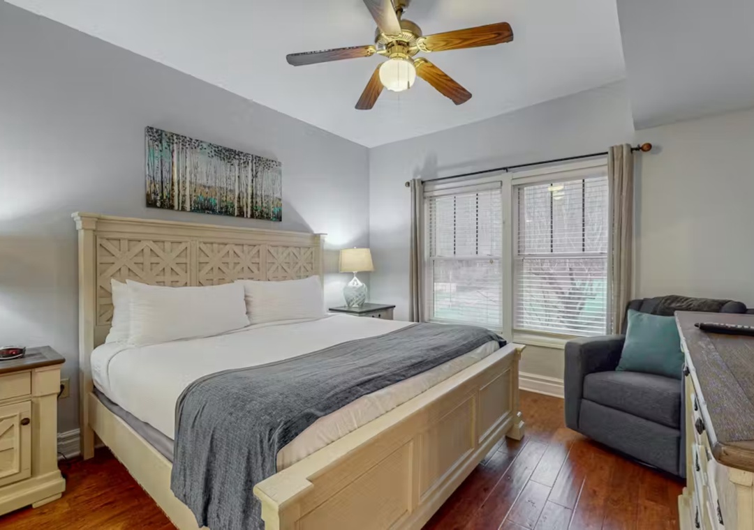 Unwind in your cozy retreat with crisp linens, a plush armchair, and warm hardwood floors beneath your feet.