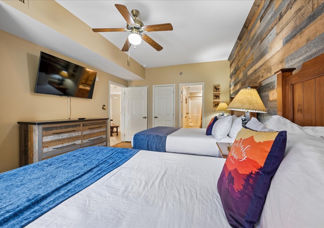 Unwind in your cozy bedroom featuring rustic wood accents, comfortable twin beds, and modern amenities for a peaceful night's rest.