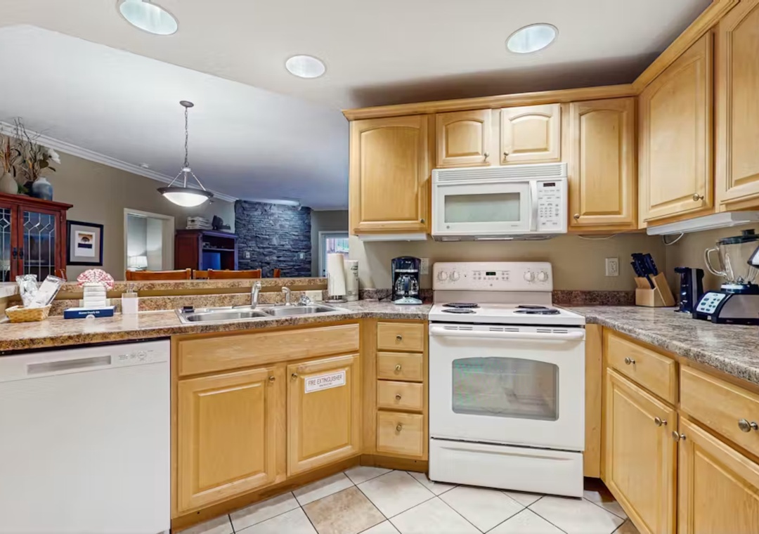 Cook your favorite meals in this fully equipped kitchen with granite countertops, warm wood cabinetry, and all modern appliances.