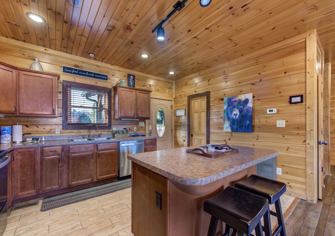 Your cabin kitchen blends rustic wood warmth with modern comfort—natural light, granite counters, and a cozy island invite you to cook, gather, and feel right at home.