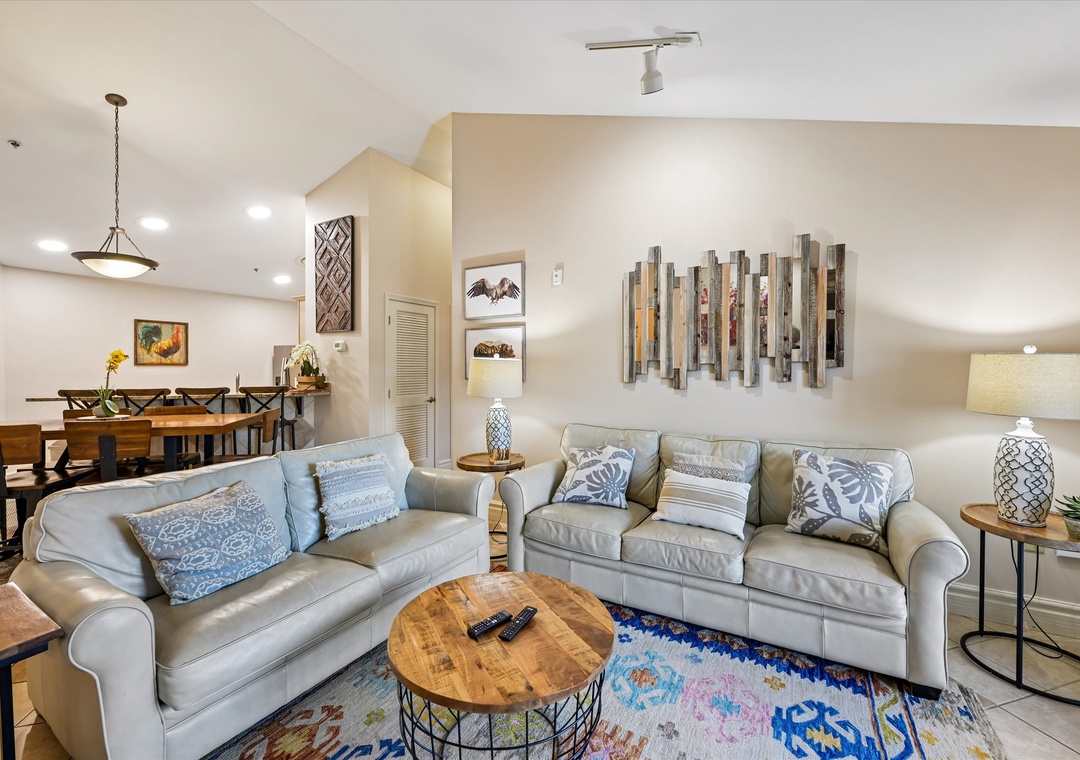 Unwind in your stylish living space with plush sofas, warm lighting, and thoughtful coastal touches that create the perfect retreat.