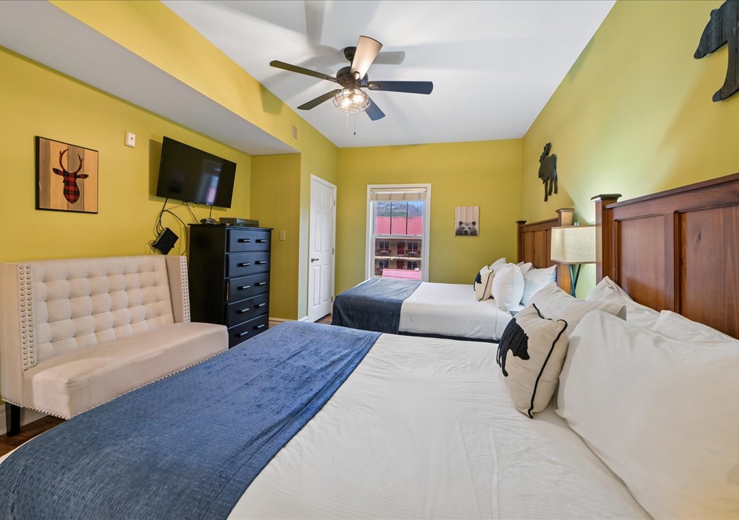 Rest peacefully in your vibrant yellow bedroom featuring two comfy beds, modern amenities, and cheerful decor that makes you feel right at home.