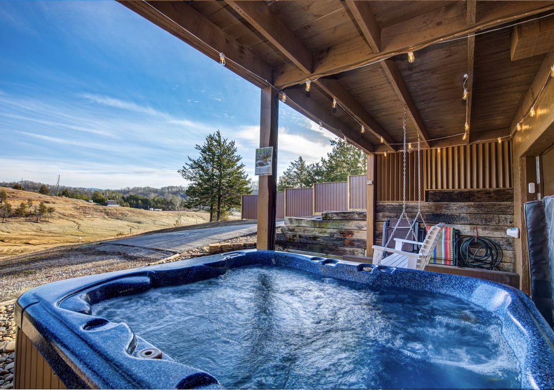 Soak in your private hot tub under exposed beams, watching rolling hills stretch endlessly beyond the covered terrace.