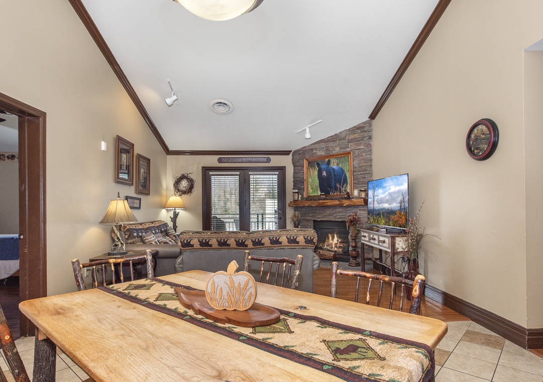 Gather around your rustic dining table while the stone fireplace crackles warmly in the background, creating perfect mountain lodge ambiance.