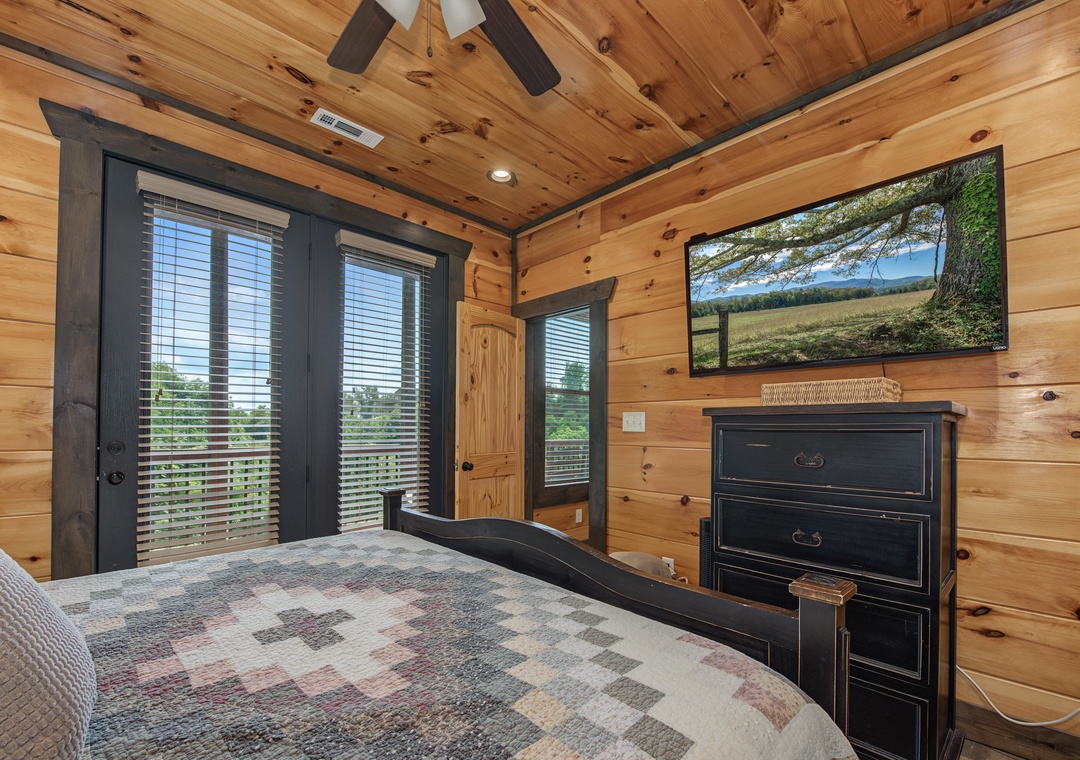 Sink into your cozy bed beneath warm wood beams and watch scenic nature views on the wall-mounted TV. French doors open to peaceful outdoor vistas for your ultimate retreat.
