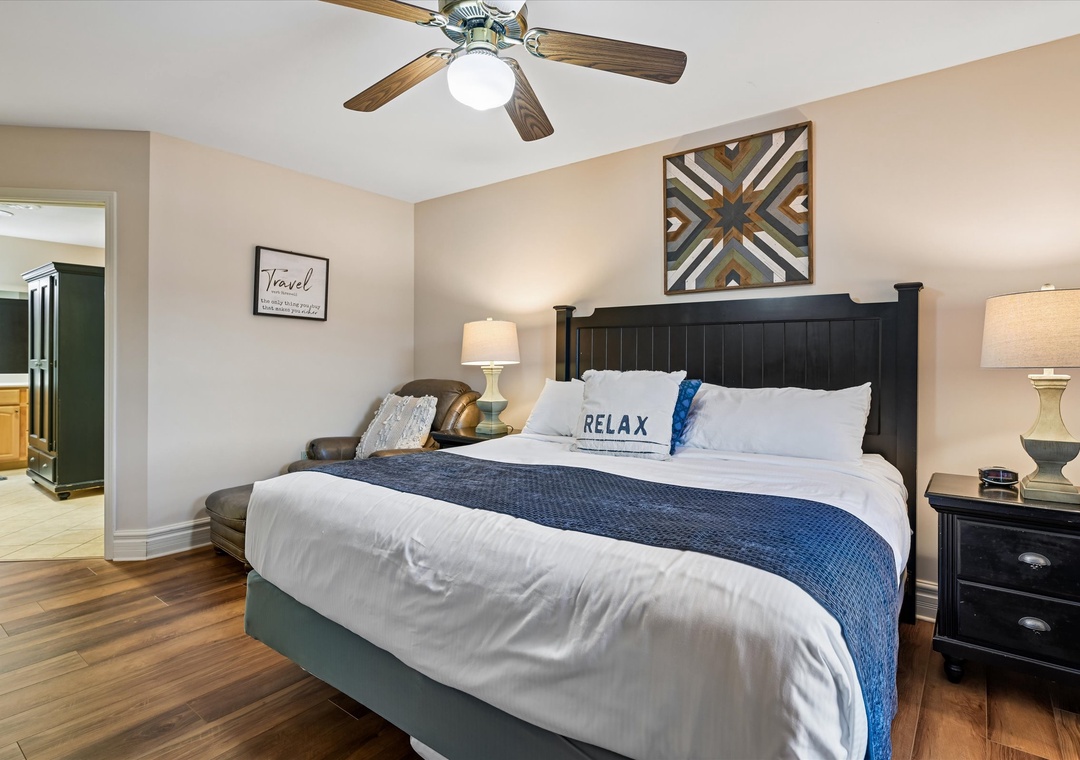 Sink into crisp white linens and let the gentle ceiling fan breeze drift you to sleep in this serene bedroom retreat.