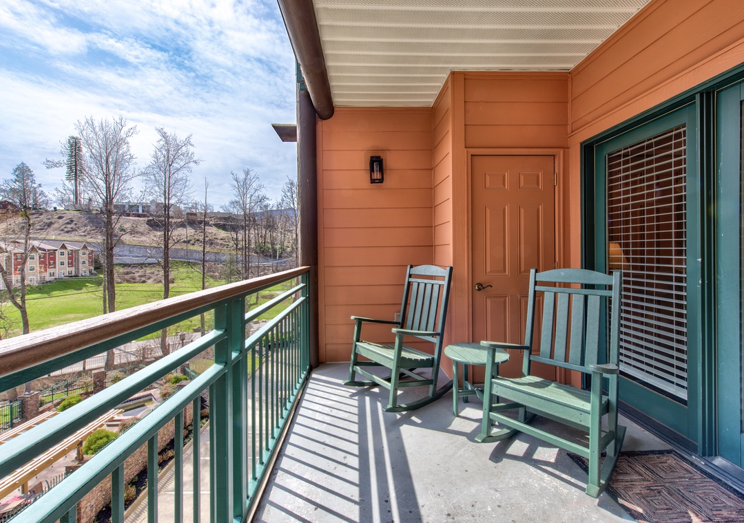 Unwind on your private balcony with comfortable rocking chairs, enjoying peaceful views and fresh air in this charming outdoor retreat.
