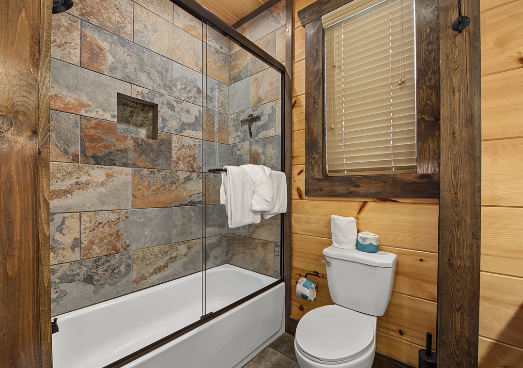 Step into your private bath where rustic wood meets natural stone. Fresh towels await, and your rain-style shower invites a refreshing start or relaxing end to your day.