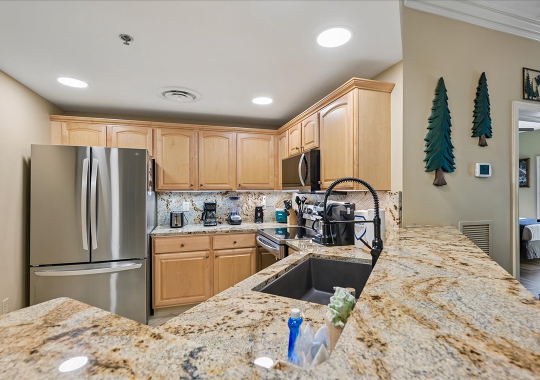 Your fully equipped kitchen features granite countertops, stainless steel appliances, and warm wood cabinets—perfect for preparing memorable meals during your stay.