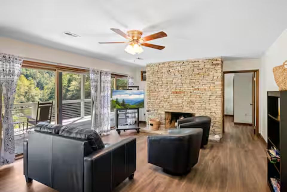 Unwind in your spacious living room with exposed brick fireplace, ceiling fan, and sliding doors to your private deck.