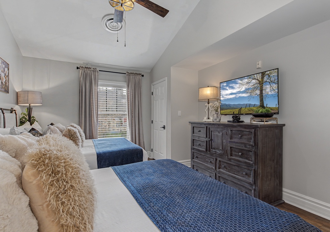 Unwind in your cozy bedroom with plush textures and soothing blues, where mountain views on the TV complement peaceful nights.