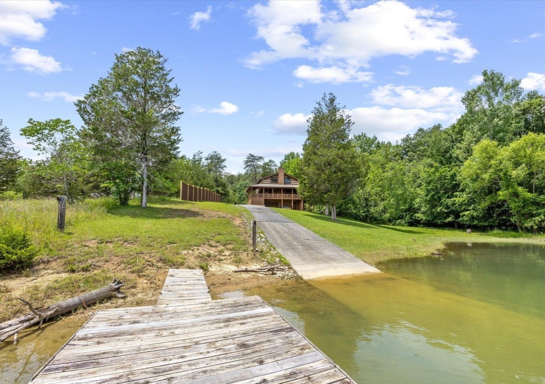 Waterfront cabin with private dock and boat launch on peaceful lake surrounded by lush forest.