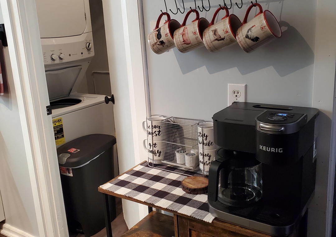 Your cozy coffee nook features a Keurig machine, charming mugs, and convenient laundry access for extended stays.