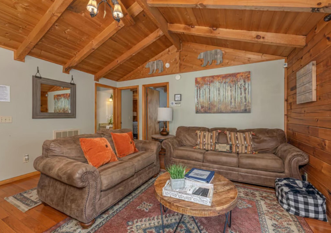 Settle in and feel right at home in this cozy living room with warm wood beamed ceilings, plush leather sofas, and mountain-inspired touches that invite you to relax.