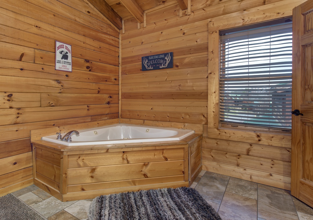 Slip into this cozy jacuzzi tub surrounded by warm wood walls for the ultimate mountain retreat relaxation experience.