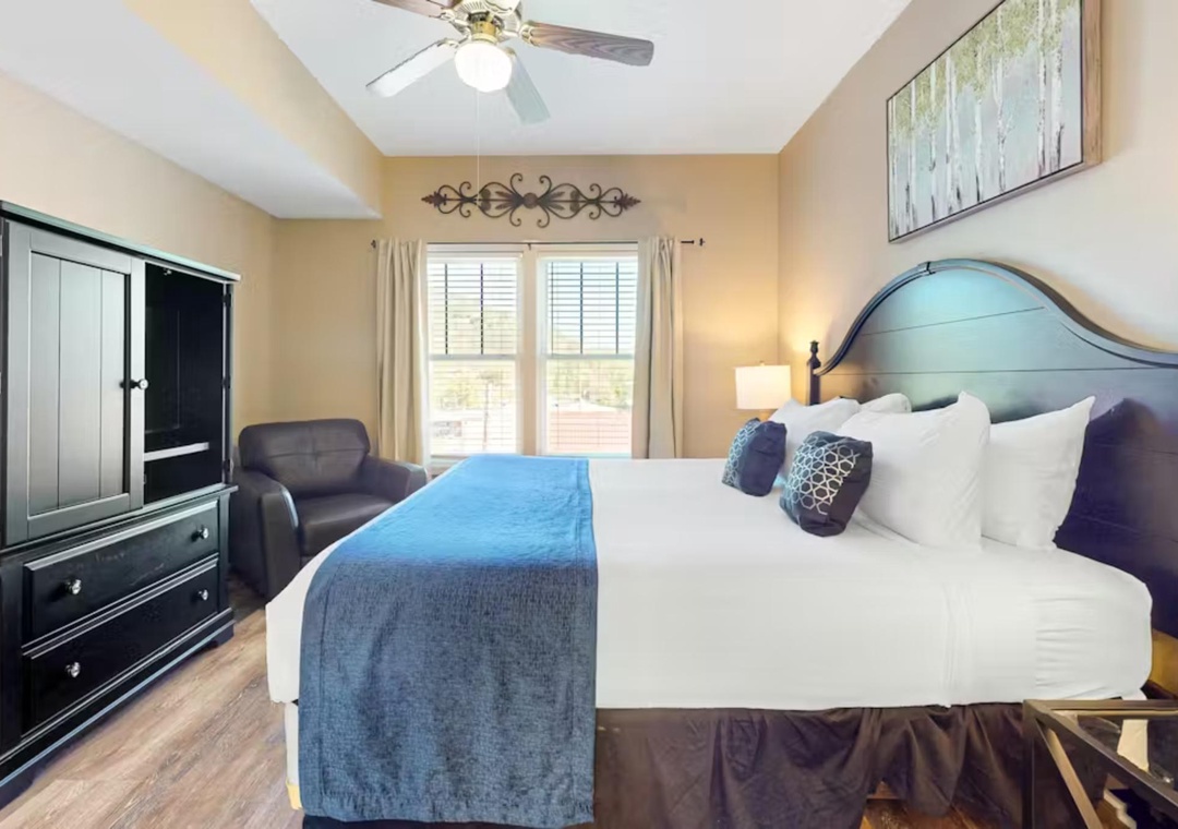 Relax in your bright bedroom with coastal charm, featuring crisp linens and a comfortable armchair for unwinding.