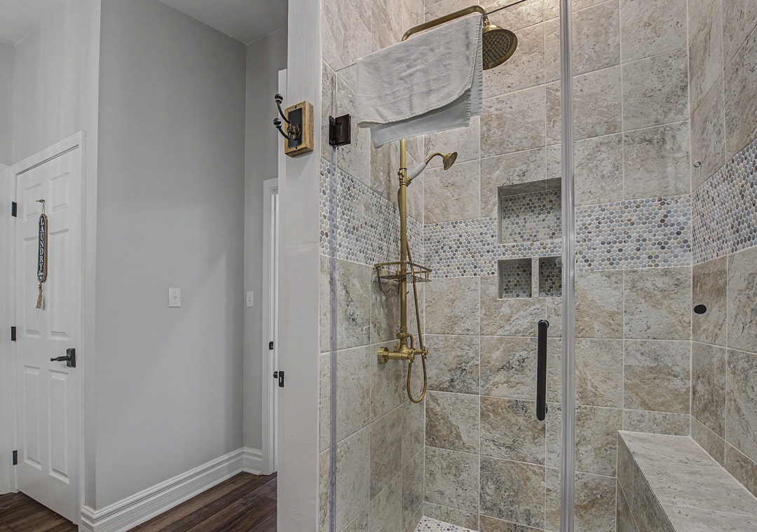 Step into your spa-like shower oasis, featuring luxurious marble tiles and gleaming brass fixtures for the ultimate relaxation experience.