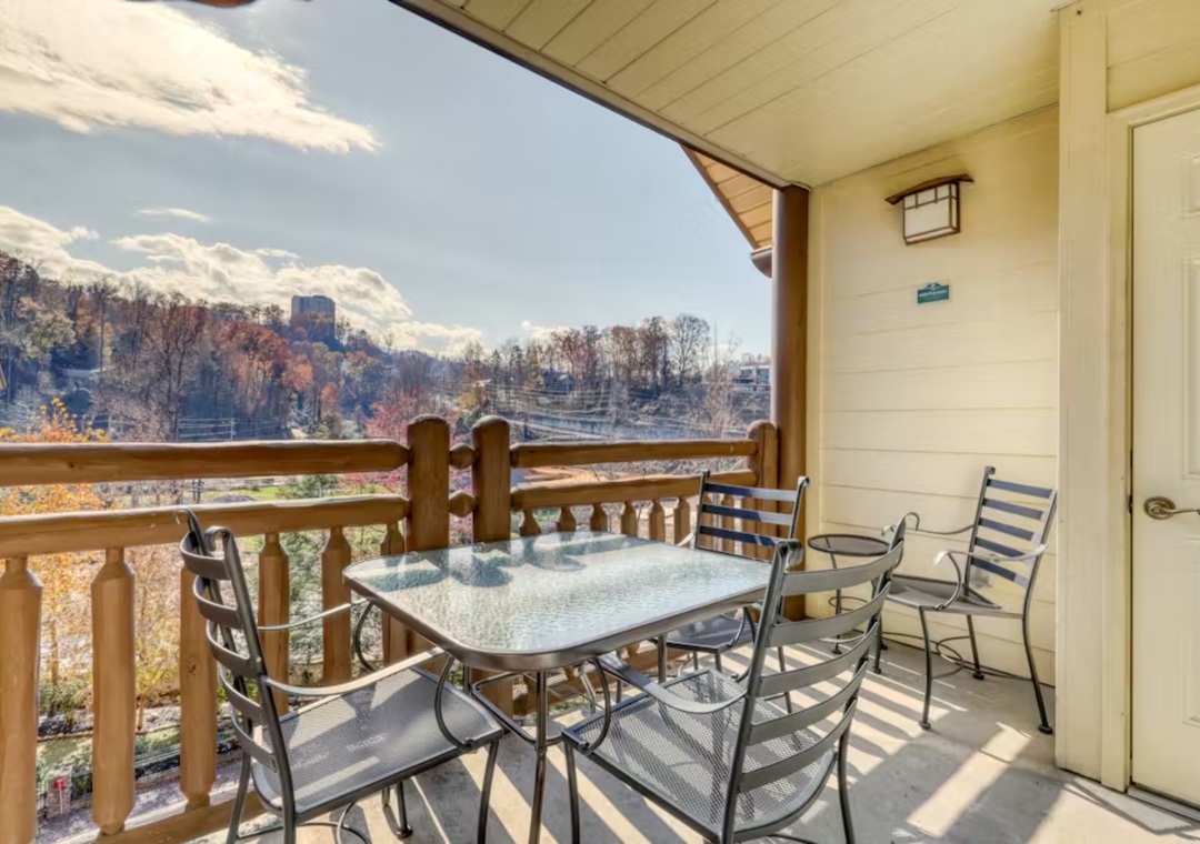 Covered balcony with mountain views and outdoor dining table for four, perfect for morning coffee or evening meals.