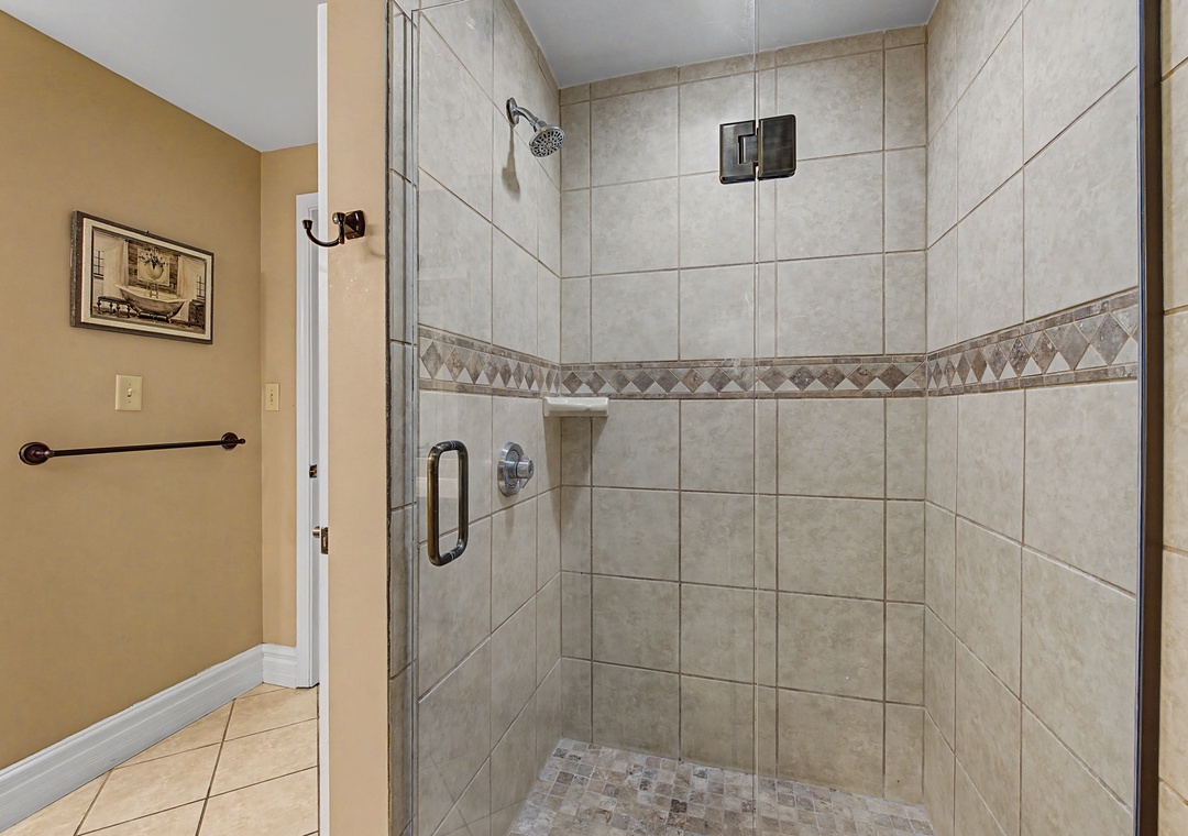 Step into your spacious walk-in shower with beautiful tile work and glass enclosure, perfect for refreshing starts to your day.
