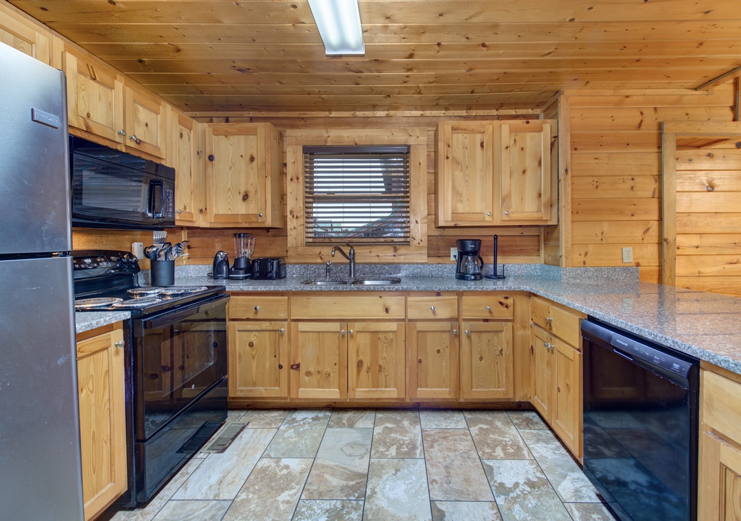 Your rustic mountain kitchen features warm wood cabinets, granite counters, and modern appliances for perfect cabin cooking.