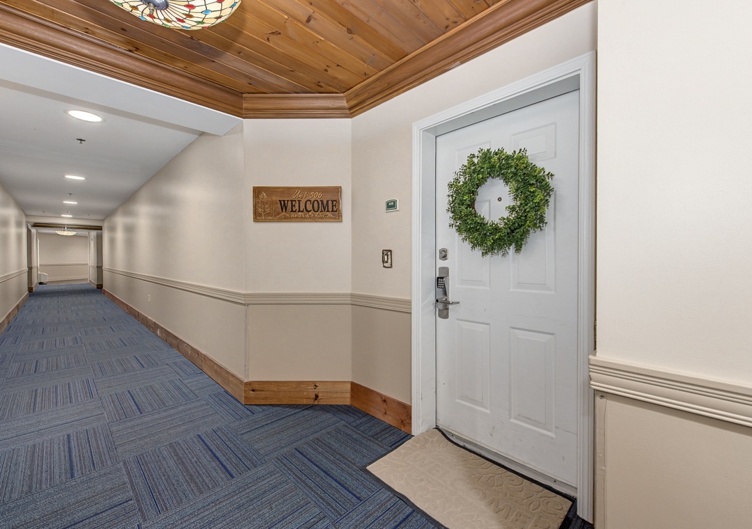 Your entrance awaits with a warm welcome wreath and charming wood-accented hallways that set a cozy, homey tone from the moment you arrive.