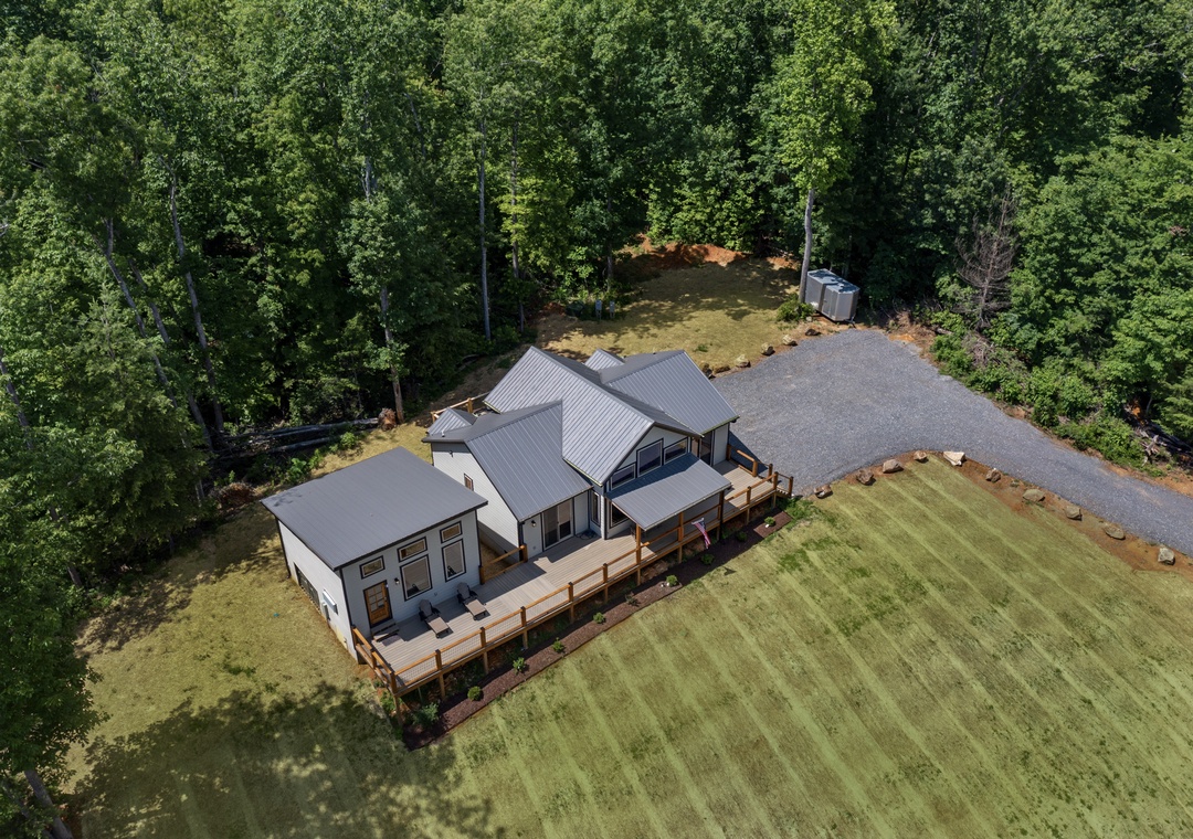 Modern vacation home nestled in a private wooded setting with spacious grounds and generous parking area.